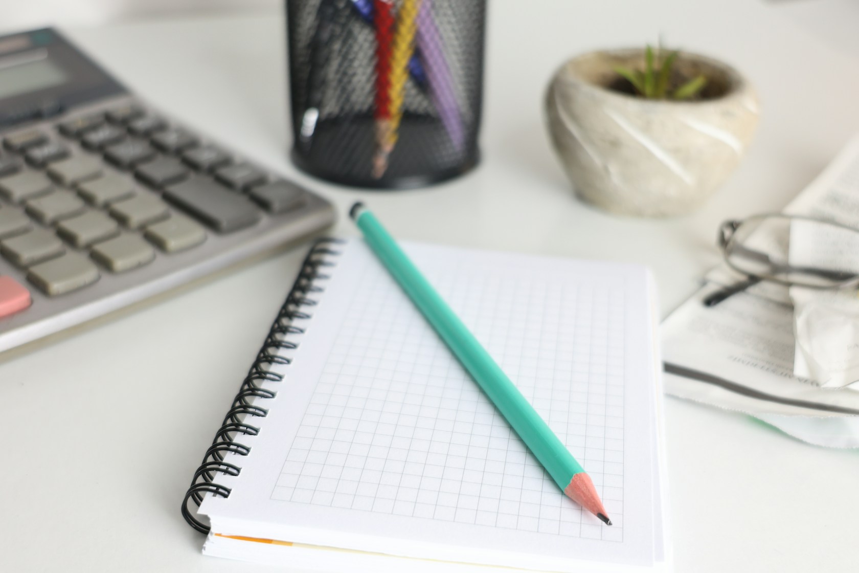 Escritorio con calculadora y cuaderno para comparar la financiación de un coche