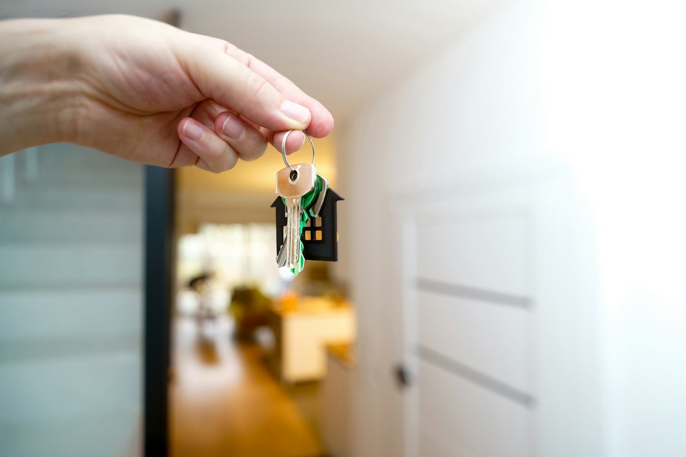 Mano entregando las llaves de una vivienda tras firmar un préstamo con un intermediario de crédito inmobiliario registrado