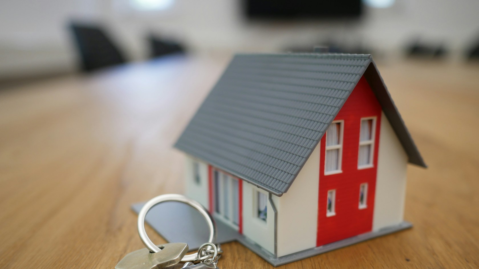 Préstamo puente: llaves y maqueta de una casa sobre la mesa, símbolo de comprar una vivienda antes de vender la actual
