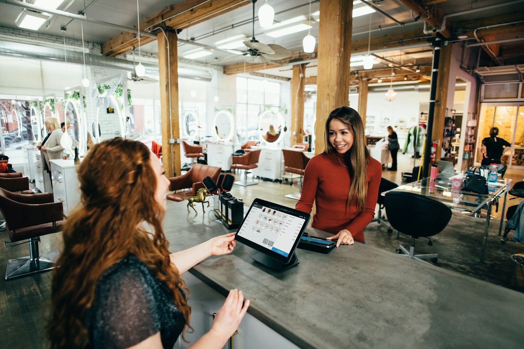 Dos emprendedoras en su cafetería revisando pedidos: préstamos ICO para autónomos y pymes 2026