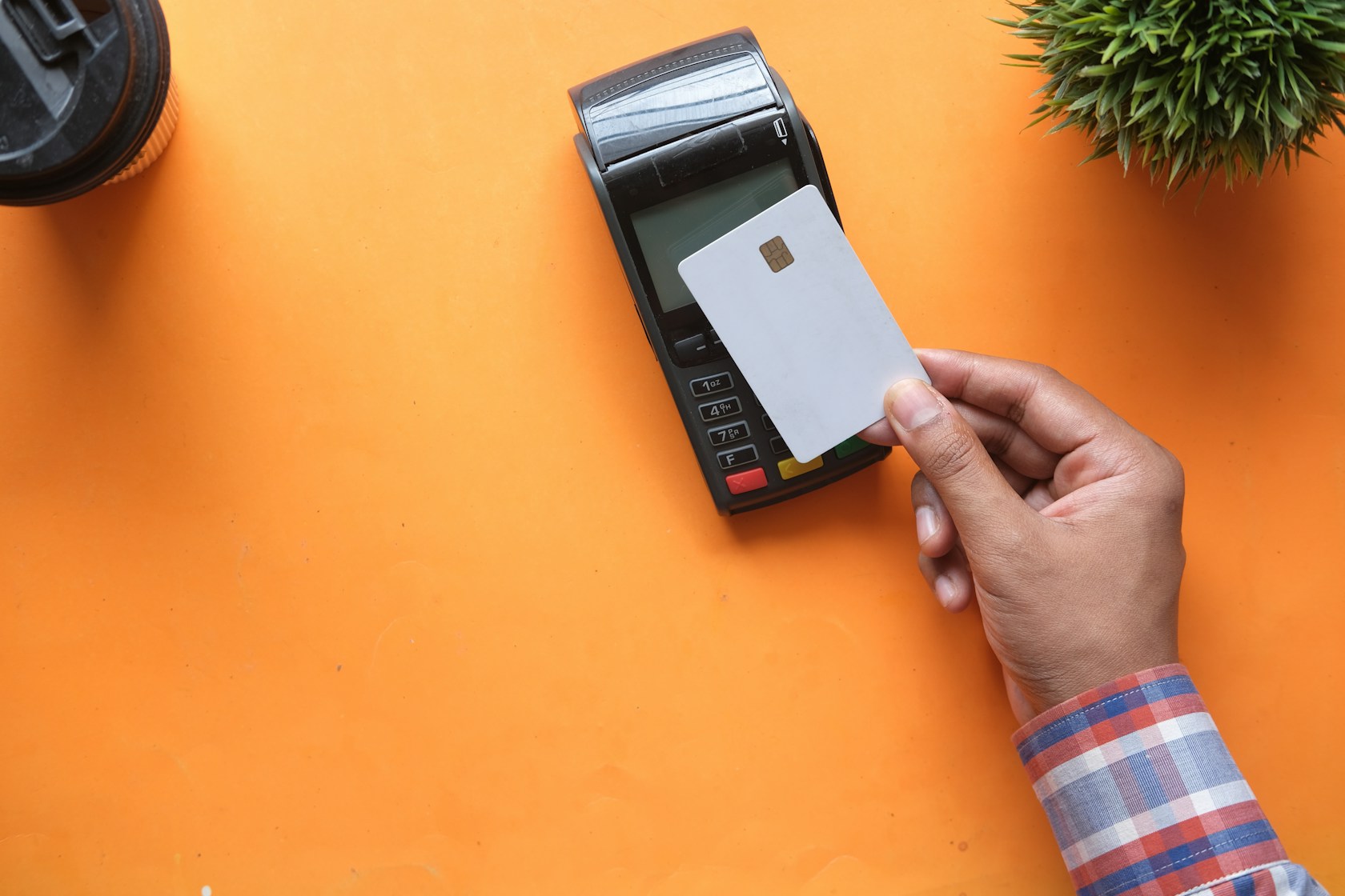 Tarjeta revolving o préstamo personal: persona sosteniendo una tarjeta junto a un datáfono